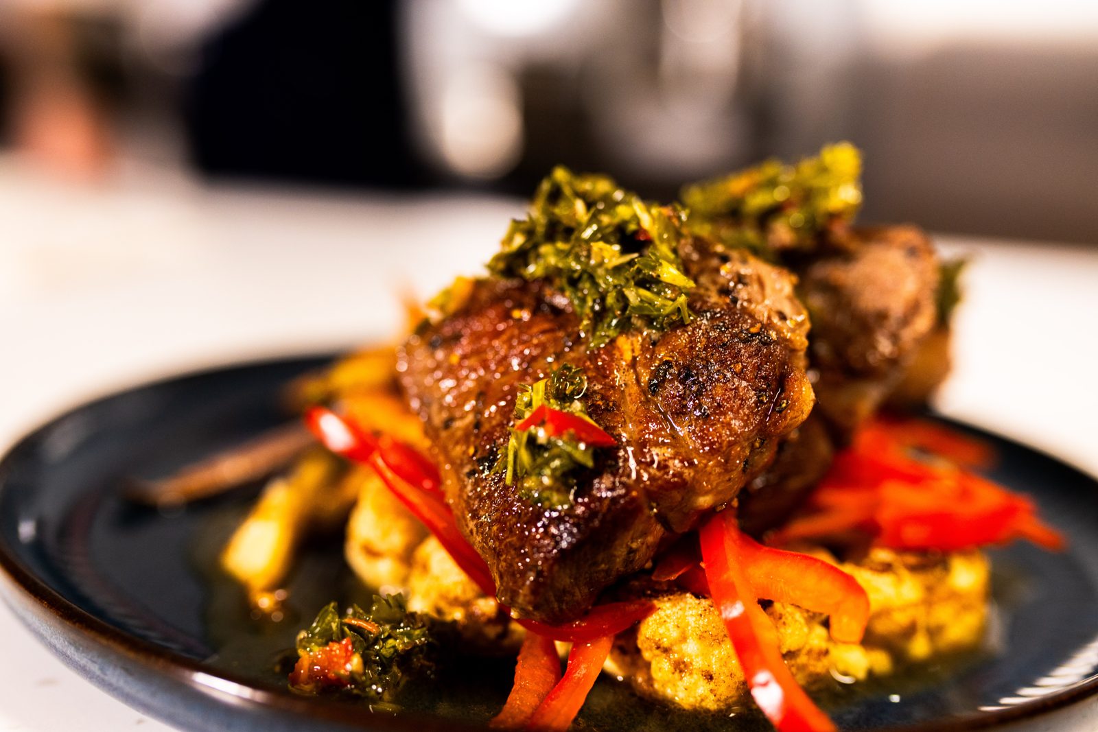 Seared beef with chimichurri over roasted cauliflower and peppers